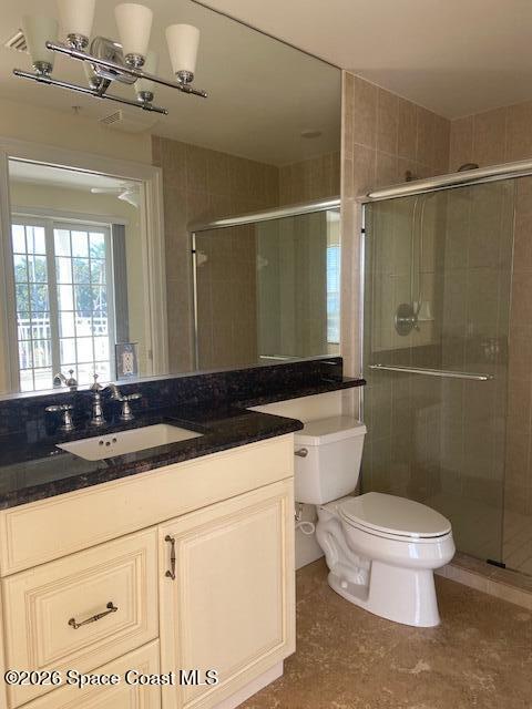 2240 Front Street, Unit 104 Melbourne, FL 32901 - Photo 30 of 37 a bathroom with a granite countertop sink a toilet a mirror and shower