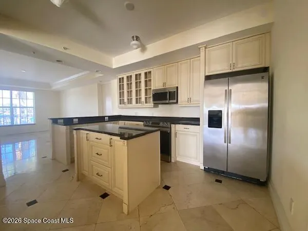 a kitchen with granite countertop a refrigerator and a sink