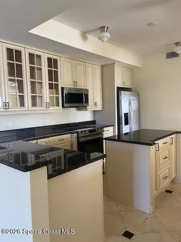 a kitchen with cabinets and steel appliances