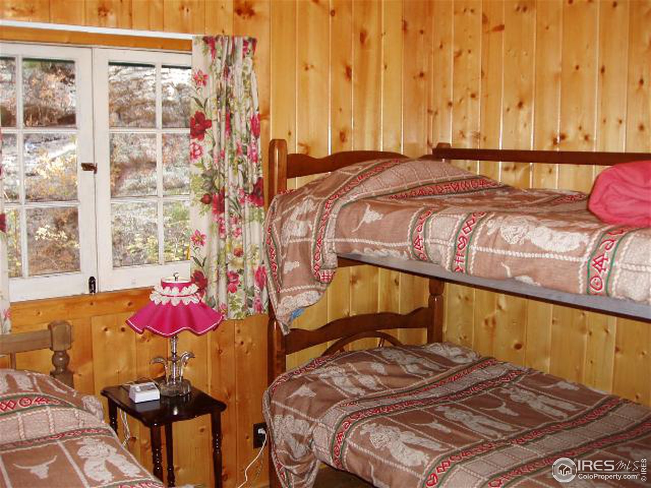 2426 Riverside Drive Lyons, CO 80540 - Photo 7 of 9 a bedroom with a bed and wooden floor