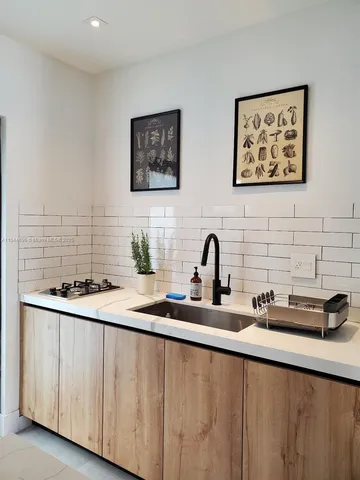 a kitchen with stainless steel appliances a sink a stove and a wooden floor