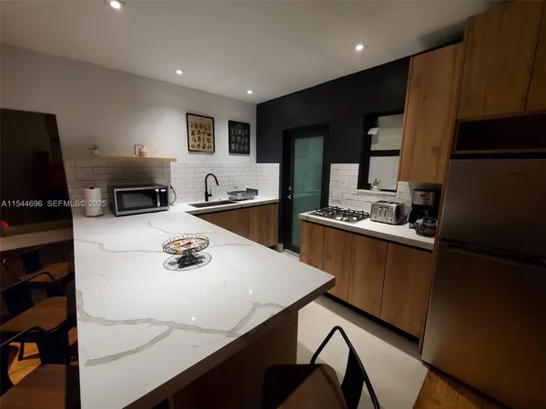 a kitchen with stainless steel appliances a stove a refrigerator a sink and a stove