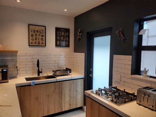 a kitchen with stainless steel appliances a stove a sink dishwasher and a refrigerator