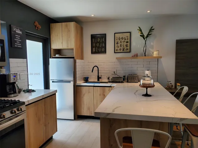 a kitchen with kitchen island a sink stove and refrigerator