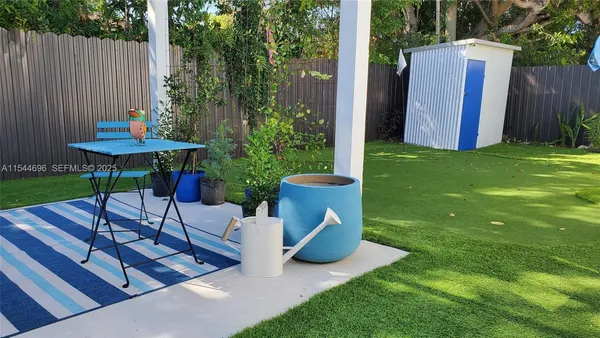 a view of a table and chairs in the back yard of the house