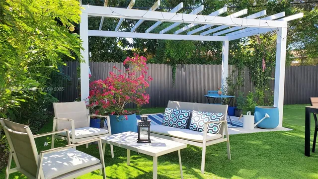 a view of a chairs and table in backyard of the house