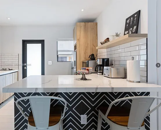 a kitchen with a sink a stove and chairs