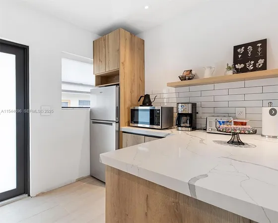 a kitchen with stainless steel appliances a stove refrigerator sink and cabinets