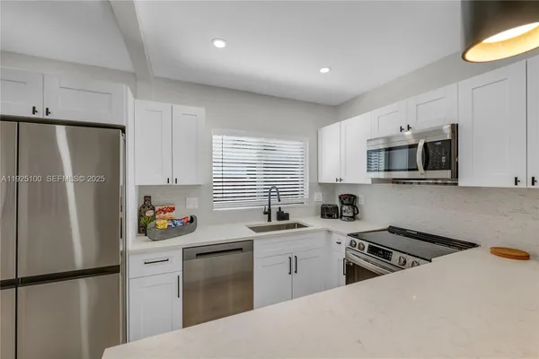 a kitchen with stainless steel appliances a refrigerator stove and sink