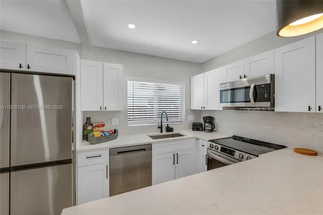 a kitchen with stainless steel appliances a refrigerator stove and sink