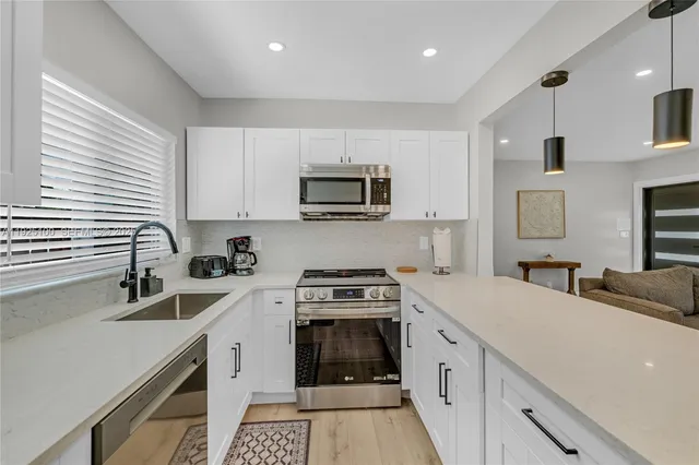 a kitchen with granite countertop a sink stove and cabinets