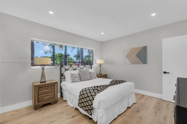 a bedroom with a large bed and a flat tv screen