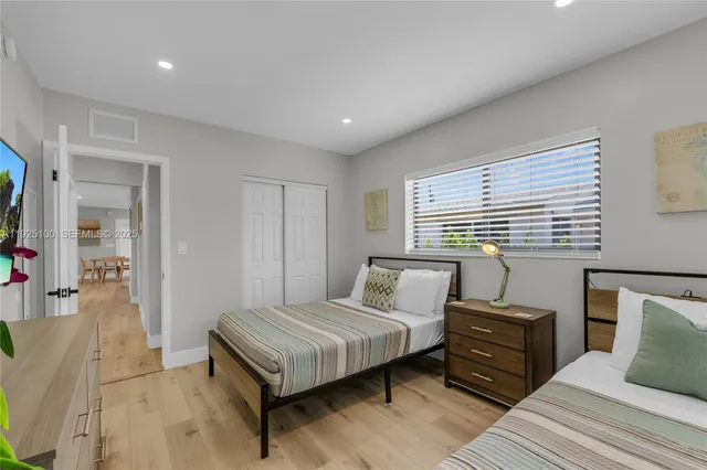 a bedroom with a bed and wooden floor