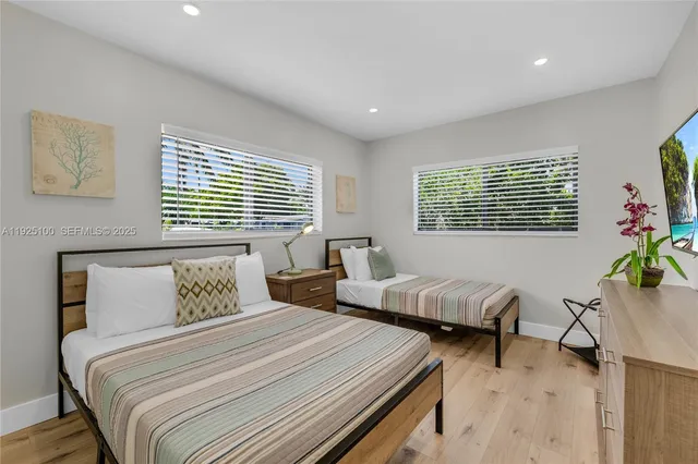 a bedroom with two beds and potted plant