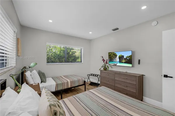 a bedroom with two beds and a dresser