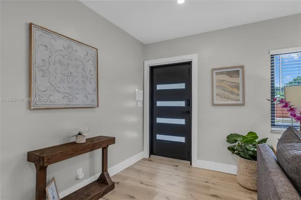 a room with painting on the wall and a potted plant