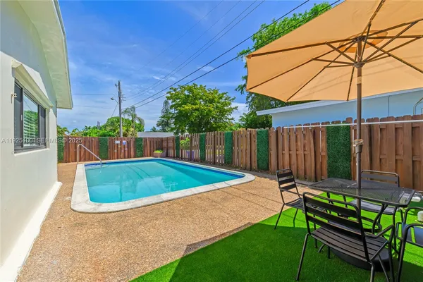 a patio with a table and chairs under an umbrella