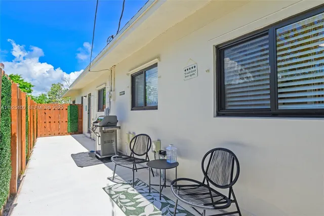 a front view of a house with a yard and palm trees
