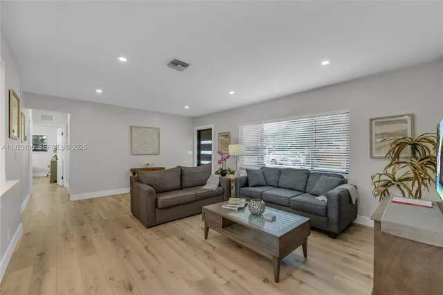 a living room with furniture and a wooden floor