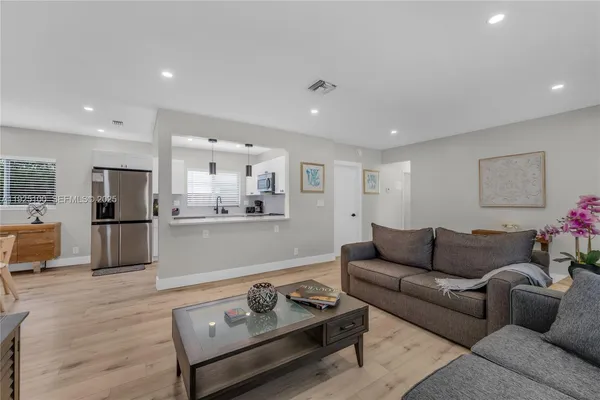 a living room with furniture and kitchen view