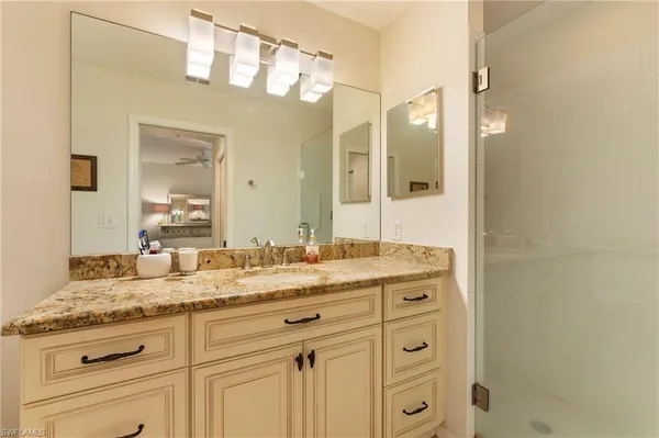 a bathroom with a granite countertop sink two mirror and a