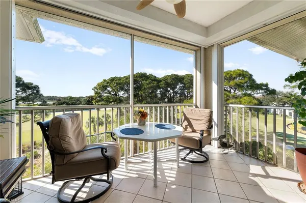 a view of a chairs and table in patio with a lake view