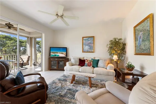 a living room with furniture a flat screen tv and a large window