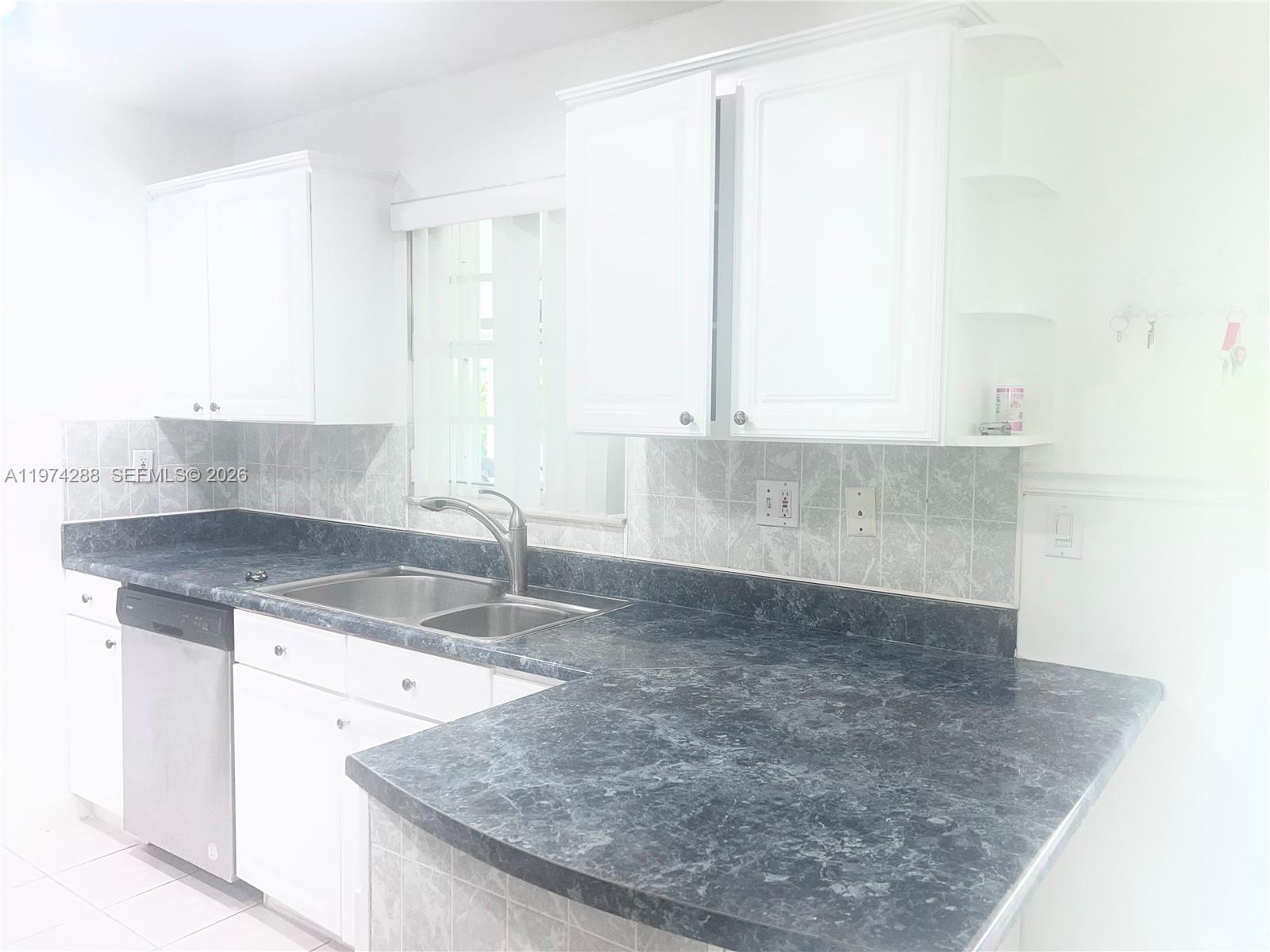 26120 Southwest 130th Avenue Homestead, FL 33032 - Photo 17 of 34 a kitchen with granite countertop a sink and a window
