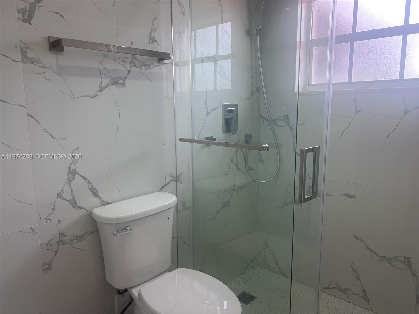 26120 Southwest 130th Avenue Homestead, FL 33032 - Photo 23 of 34 a white toilet sitting next to a bathroom sink