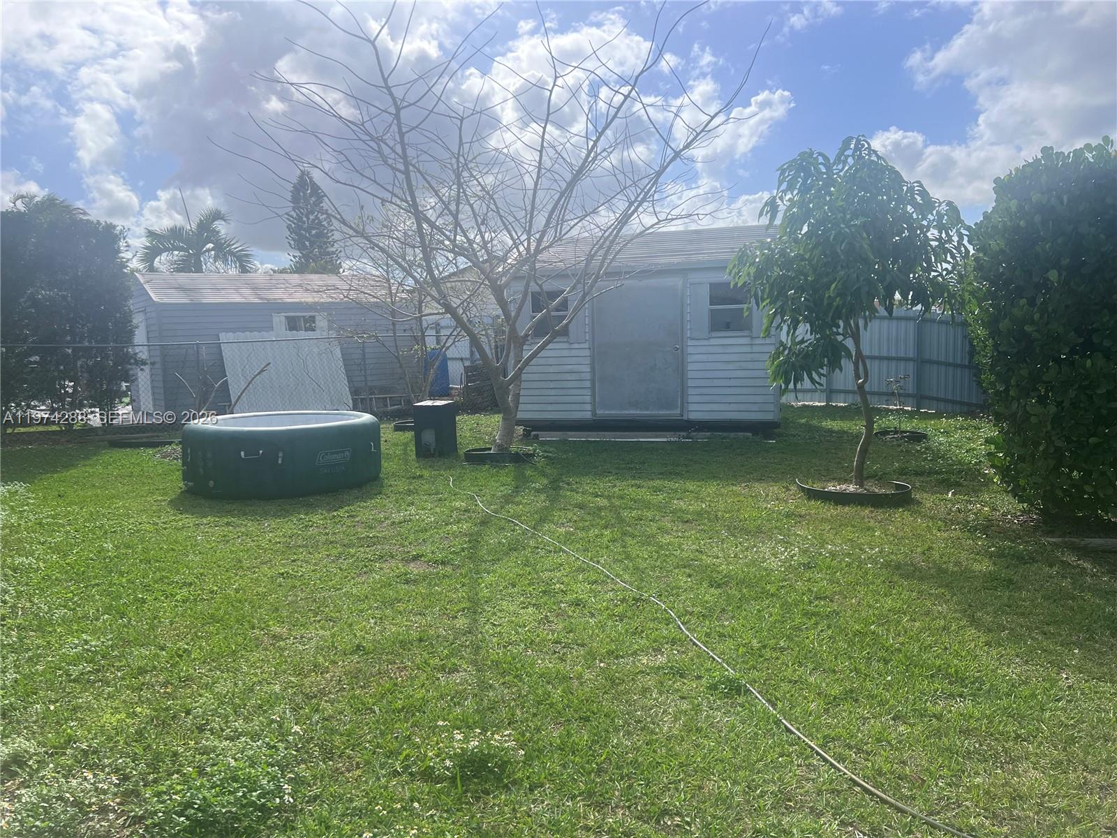 26120 Southwest 130th Avenue Homestead, FL 33032 - Photo 7 of 34 a backyard of a house with fountain table and chairs