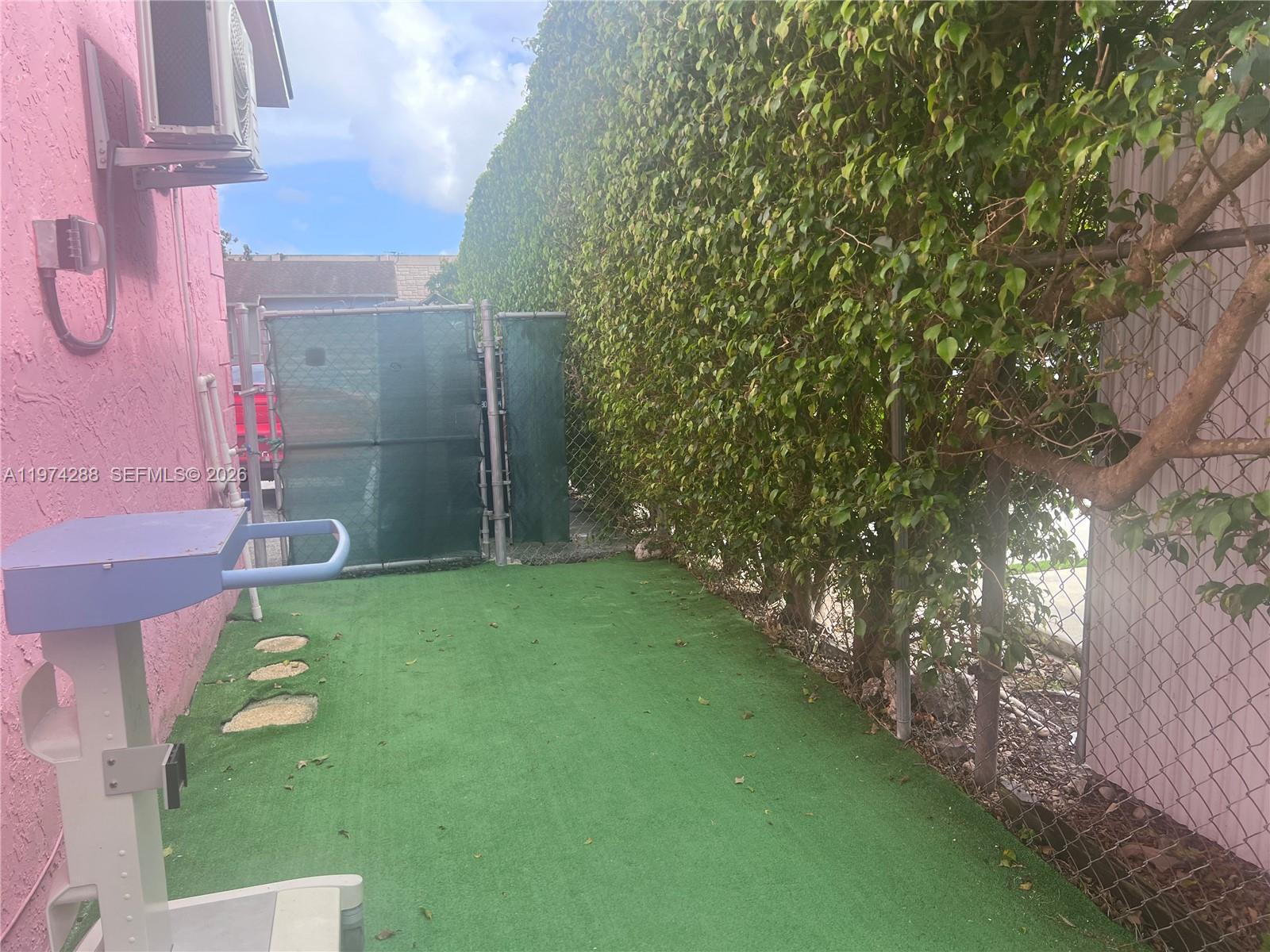 26120 Southwest 130th Avenue Homestead, FL 33032 - Photo 10 of 34 a backyard of a house with lots of green space and fountain