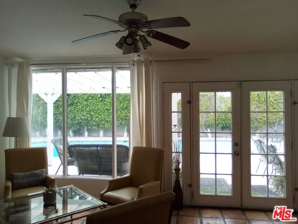 a living room with furniture and a floor to ceiling window