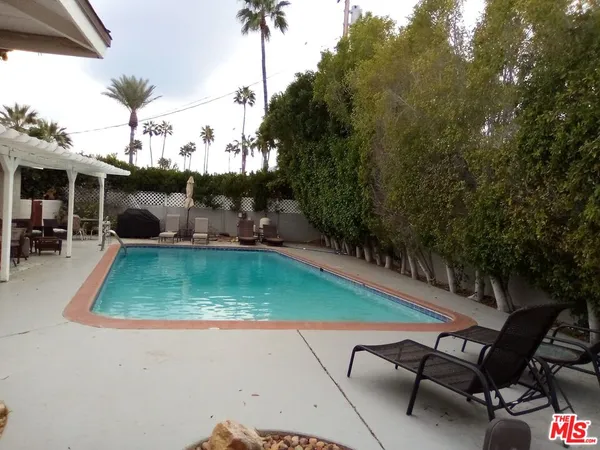 swimming pool view with a seating space