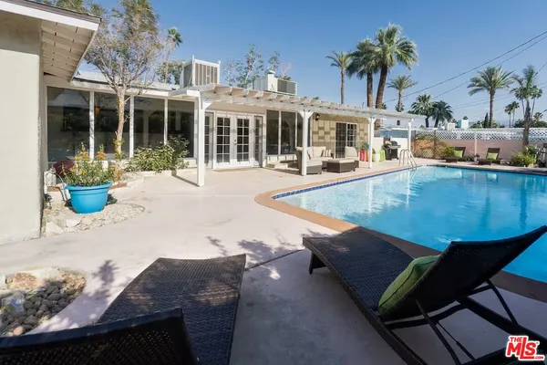 a view of a house with pool and chairs