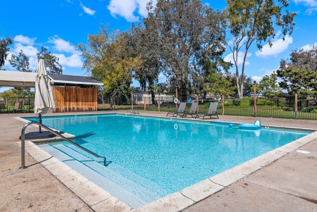 12939 Cree Court Poway, CA 92064 - Photo 4 of 15 a view of a swimming pool with a bench and trees around