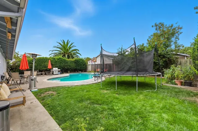 a view of swimming pool with a garden and plants