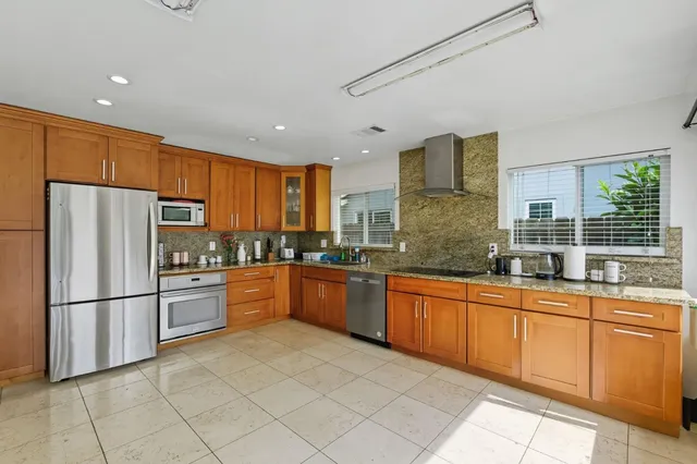 a kitchen with granite countertop stainless steel appliances a refrigerator sink and microwave