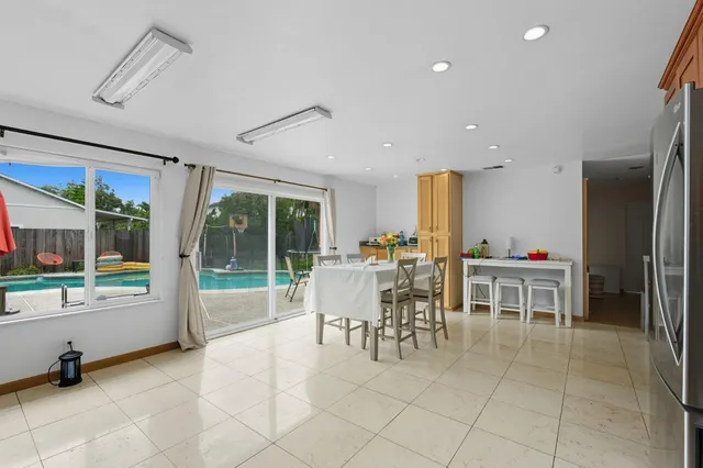 a dining room with furniture and a floor to ceiling window