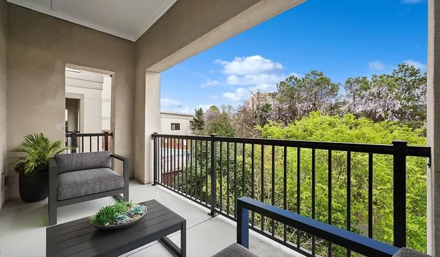 a view of a balcony with couches potted plants and sky view