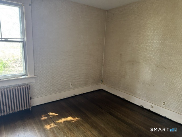 408 Huntington Road Scotland, CT 06264 - Photo 5 of 10 an empty room with wooden floor and windows