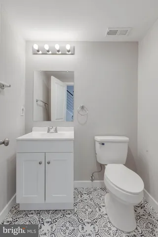 a bathroom with a sink a toilet and mirror