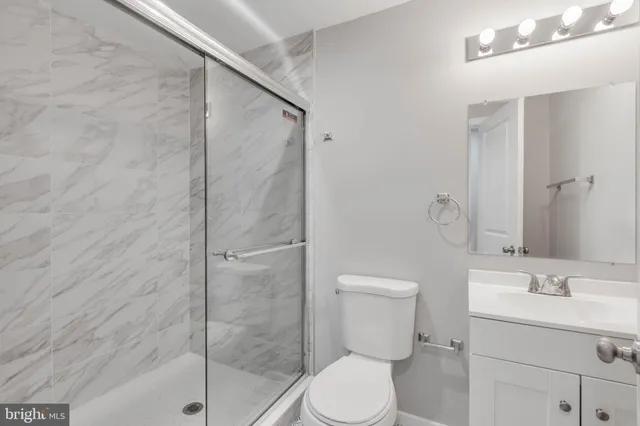 a bathroom with a granite countertop sink toilet and shower