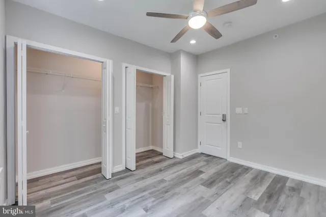 an empty room with wooden floor a ceiling fan and closet