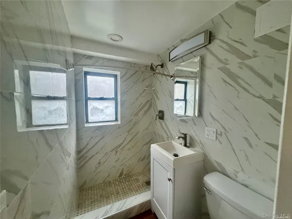 a bathroom with a sink and mirror with toilet
