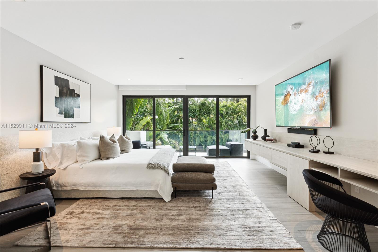 4060 Woodridge Road Miami, FL 33133 - Photo 11 of 49 a spacious bedroom with a large bed and a flat screen tv