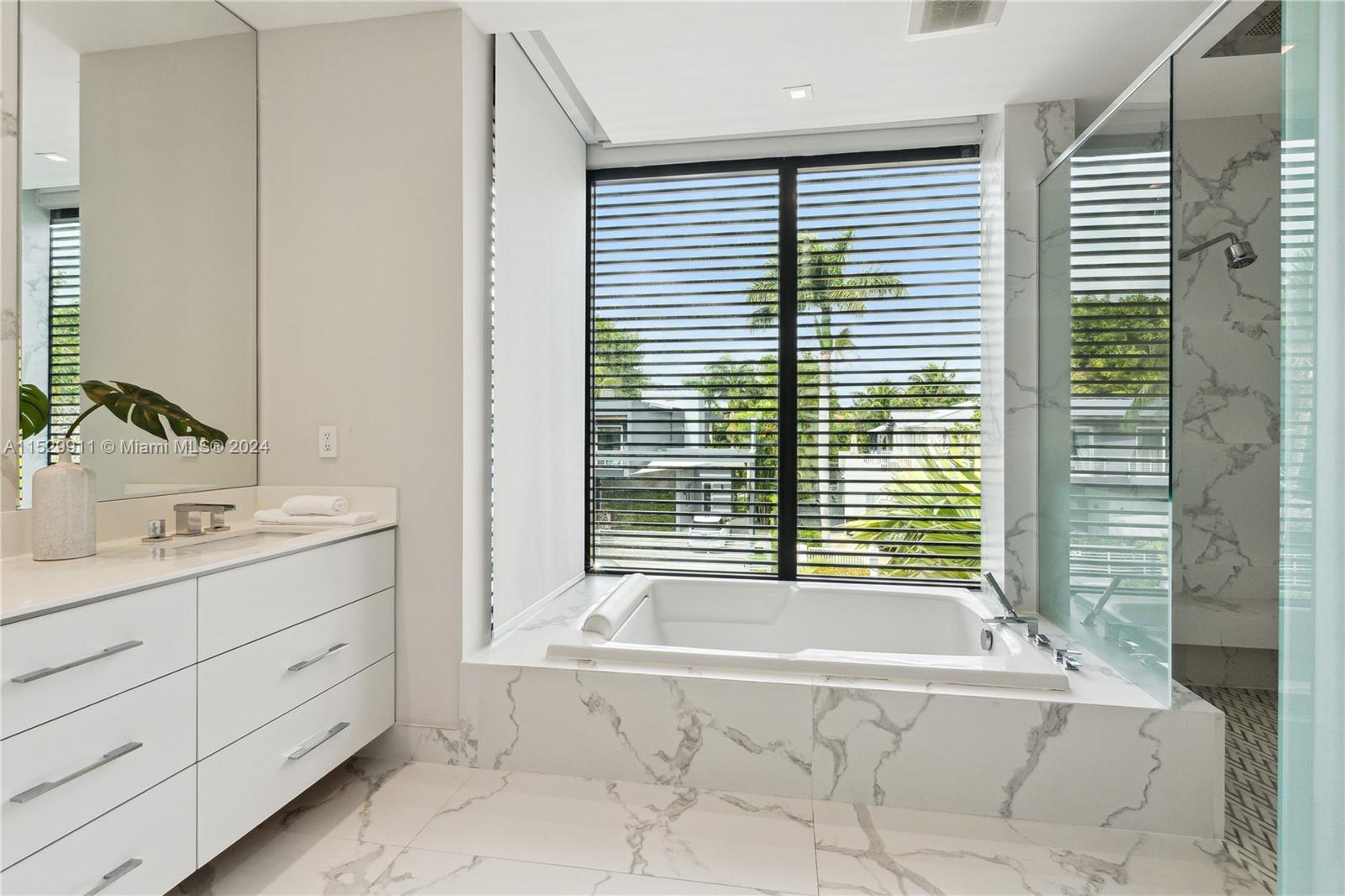 4060 Woodridge Road Miami, FL 33133 - Photo 15 of 49 a bathroom with a tub sink and mirror