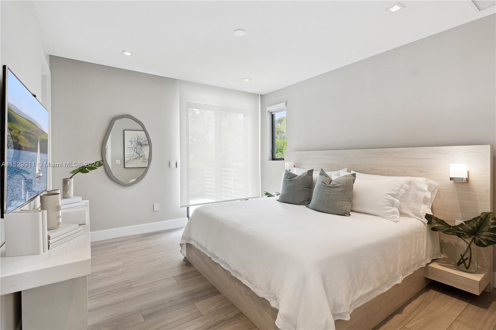 4060 Woodridge Road Miami, FL 33133 - Photo 22 of 49 a large bed sitting in a bedroom next to a window with bathroom