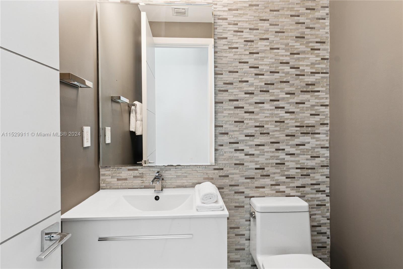 4060 Woodridge Road Miami, FL 33133 - Photo 25 of 49 a bathroom with a toilet sink and mirror