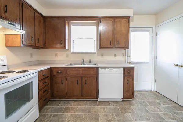 a kitchen with a stove sink and cabinets