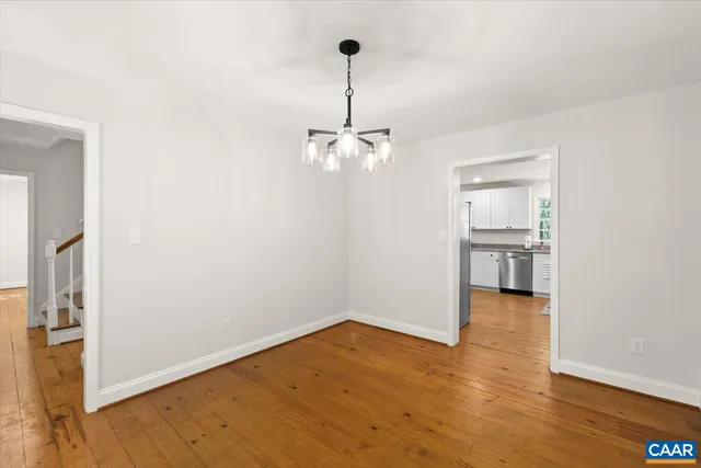a view of a room with wooden floor kitchen view and a window